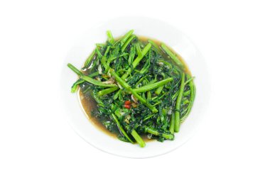 Sabah şatafatıyla kızartılmış Tayland usulü, ahşap arka planda acı biberli ve soya soslu hızlı kızarmış su ıspanağı. Ateş edilmiş sabah zaferi beyazda izole edilmiş