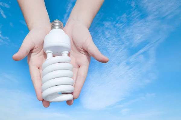 Energibesparande Koncept Kvinna Hand Hålla Glödlampa Blå Himmel Bakgrund Idéer — Stockfoto