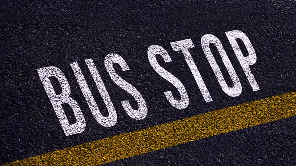 バス停のテキストとアスファルト道路の真ん中に道路上の黄色い行 路上のバス停の単語 — ストック写真