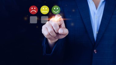 İş adamı gülen surat ikonunu seçiyor. Geri bildirim derecesi ve olumlu müşteri değerlendirme deneyimi, memnuniyet anketi. Akıl sağlığı değerlendirmesi. Dünya Ruh Sağlığı Günü konsepti