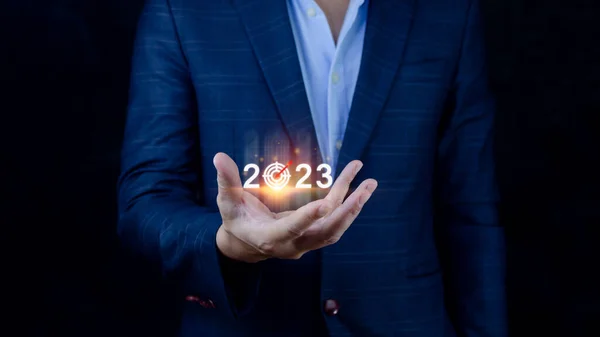 Business target and goal 2023 icon, hand pointing holding 2023 virtual screen, Start new year 2023 with a goal plan, action plan, strategy, new year business vision.
