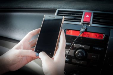 El ele tutuşan akıllı telefon, insanlar araba sürerken telefona basıyor.