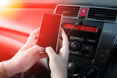 El ele tutuşan akıllı telefon, insanlar araba sürerken telefona basıyor.