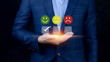İş adamı gülen surat ikonunu seçiyor. Geri bildirim derecesi ve olumlu müşteri değerlendirme deneyimi, memnuniyet anketi. Akıl sağlığı değerlendirmesi. Dünya Ruh Sağlığı Günü konsepti
