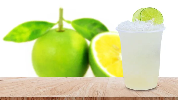 清凉新鲜的柠檬水在一个塑料杯子里 加碎冰块和柠檬片 放在白色背景的木制桌子上 — 图库照片