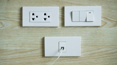 Elektrik şalteri ve ahşap duvarın fişi, AC güç prizleri ve prizleri, beyaz prizler soketi ve duvardaki kablolu TV prizi..