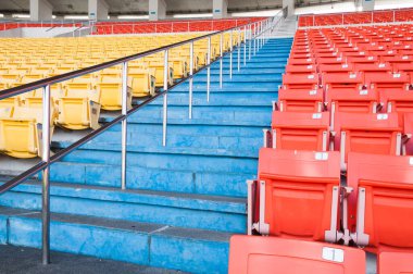 Stadyumda boş turuncu ve sarı koltuklar, futbol stadyumunda sıra sıra koltuk.