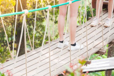 Turist ahşap asma köprüsünde uzaklaşıyor, ormanın diğer tarafına geçiyor.