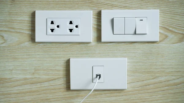 木质墙壁上的电源开关和插头 墙上的交流插座和插座 白色插座插座和有线电视插座 — 图库照片