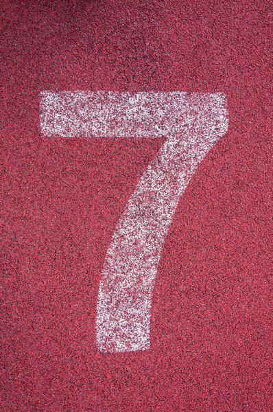 Number seven on running track. White track number on red rubber racetrack, texture of running racetracks in stadium