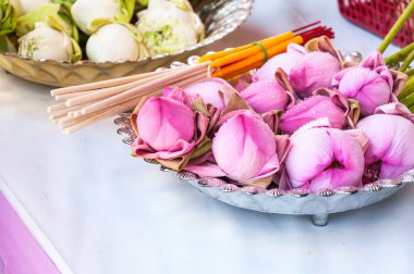 Pembe nilüfer çiçeği, tütsü çubukları ve tapınaktaki Buda 'ya dua etmek için mumlar.