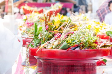 Wat che di Luang Chiang Mai, Tayland 'da Budist rahiplere yapılan geleneksel çiçek töreninin arka planında tütsü, mum ve çiçekler var.