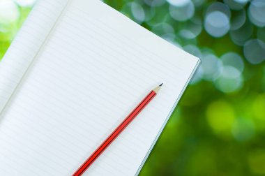 Sanat eğitimi için soyut doğa yeşil bokeh arkaplan üzerinde kalem izolasyonu olan defter