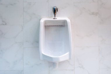 Erkekler tuvaletinde eski beyaz pisuarlar.