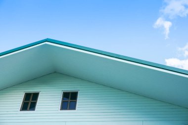 Yeşil çatının simetrik detaylı görüntüsü mavi gökyüzü ile havalandırma panelini gösteriyor