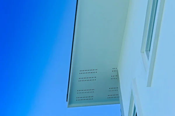Крыша Дома Дождевой Канализацией Верхнего Дома Большими Окнами Голубом Фоне — стоковое фото