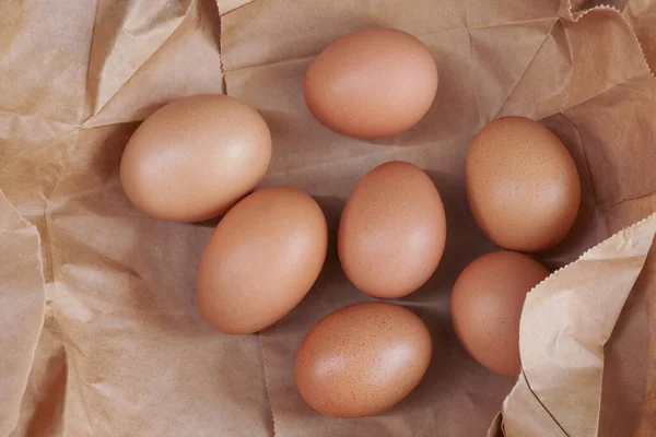Коричневое Яйцо Бумажном Пакете Позади Свежие Куриные Яйца Деревянном Столе — стоковое фото
