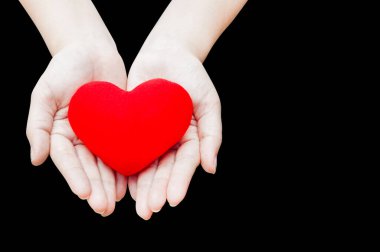 Kızıl Yürek 'i kadın ellerine kapat, karanlık arka planda, sağlıkta, tıpta, insanlarda ve kardiyoloji kavramında izole et.