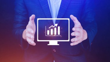 İş adamı grafikte iş büyümesini gösteriyor. Eller grafiklere dokunuyor. Sanal arayüz teknolojisi ve finansal sembollerle artan karı temsil ediyor.