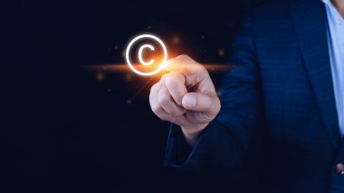 Telif hakkı ikonu, patentler ve fikri mülkiyet koruma yasası ile haklara dokunan bir işadamı. telif haklarının sembolü. Yazarın telif hakkı sembolü..