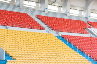 Stadyumdaki boş turuncu ve sarı koltuklar, futbol stadyumundaki sıralar.