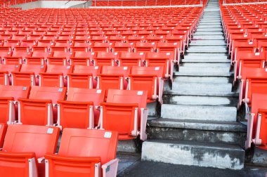 Stadyumdaki boş turuncu koltuklar, futbol stadyumundaki sıralı yürüyüş yolları.