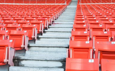 Stadyumdaki boş turuncu koltuklar, futbol stadyumundaki sıralı yürüyüş yolları.