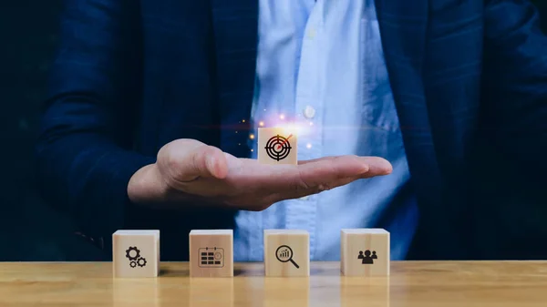 stock image Concept of business planning strategy, hand choose the wooden cube block with icon aiming goal icon Action plan,success and business target concept,company strategy development.