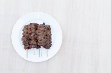 Tahta arka planda bambu çubuklu ızgara domuz eti, Tayland usulü ızgara domuz barbeküsü.