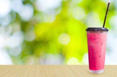 Buzlu çay, yeşil arka planda buzlu pembe süt çayı, buzlu yaz içecekleri.