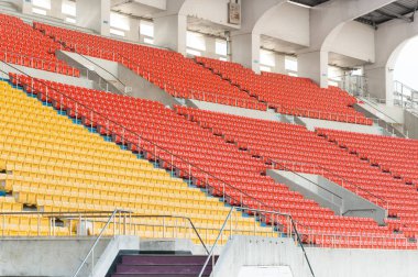 Stadyumdaki boş turuncu ve sarı koltuklar, futbol stadyumundaki sıralar.