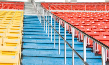 Stadyumdaki boş turuncu ve sarı koltuklar, futbol stadyumundaki sıralar.
