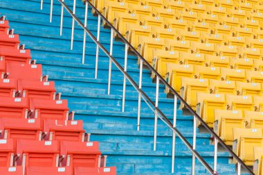 Stadyumdaki boş turuncu ve sarı koltuklar, futbol stadyumundaki sıralar.