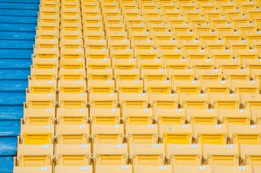 Stadyumdaki boş sarı koltuklar, futbol stadyumundaki sıralar, seçilmiş odak.