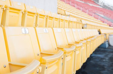 Stadyumdaki boş sarı koltuklar, futbol stadyumundaki sıralar, seçilmiş odak.