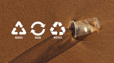 Plastik bardaktaki küçültme, yeniden kullanma, geri dönüşüm sembolü plajda atık doğayı kirleten, ekolojik atık yönetimi ve sürdürülebilir ve ekonomik yaşam tarzı için ekolojik metafor olarak bırakılır..