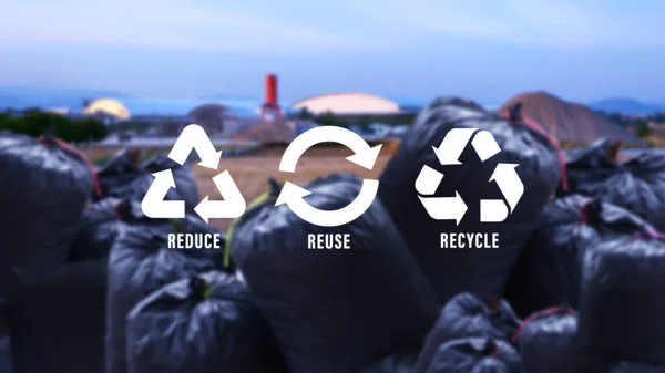 Reduce, reuse, recycle symbol on black garbage bags of rubbish on industry background, ecological metaphor for ecological waste management and sustainable and economical lifestyle.