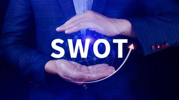 Businessman hand holding swot analysis strategy diagram for business plan and growth, SWOT analysis concept.