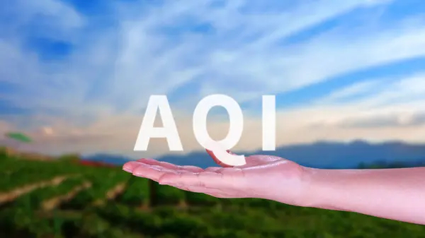 AQI, Abbreviation of air quality index, hand holding AQI on nature background, environment concept.