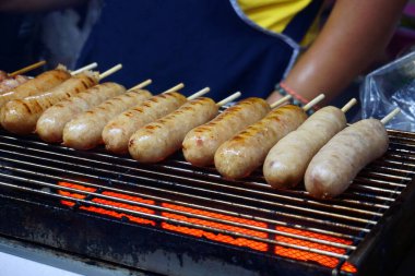 Isaan sosisi, ekşi bir tadı var. Bir et karışımı sarımsak ve pirinç birlikte mayalanır. Thai yemeği, E Saan Sausage sokak yemeği.