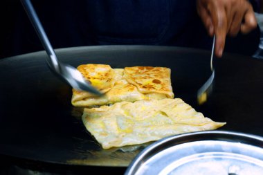 İnsanlar Tayland 'da sokak yemeği olan Roti Canai' yi yapmak için para saçıyor.