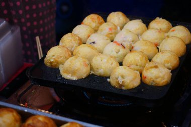 Takoyaki sıcak tavada yemek pişirirken Japonya, Asya demir tabakları, Asya takoyaki Japon sokak yemekleri.