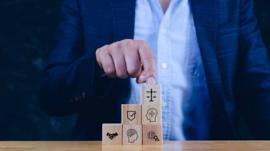 Yapay zeka etiği ya da yapay zeka hukuk kavramı. Yapay zekanın insanlıkla dengelenmesi, yapay zekanın ahşap küp üzerindeki yapay zeka etiği, yasal ölçeklerin sembolleri, güvenlik, etik standartlar ve yapay zeka teknolojisindeki düzenlemeler.