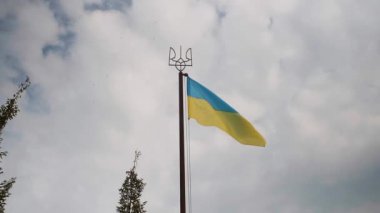 Ukrayna bayrağı, Obolon 'un başkenti Kyiv' de bulutların ve kuşların arka planında dalgalanır.