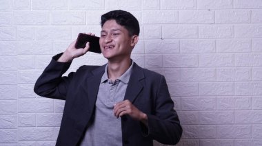 Gri gömlekli Asyalı adam mutlu ve başarılı.