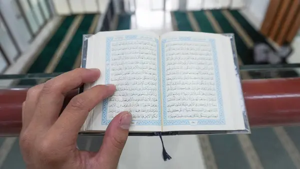 Hands are grasping the Quran, Ramadan Mubarak Islam Muslim