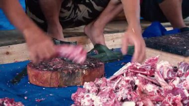 Kurban, inekleri boğazlayarak ve kaburgaları ayırarak kamu hizmeti yaparak.