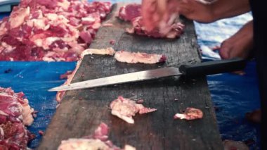 Kurban, inekleri boğazlayarak ve kaburgaları ayırarak kamu hizmeti yaparak.