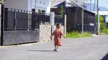 Bebek mutlu görünüyor ve temiz ve ferahlatıcı sabah havasının tadını çıkarıyor, neşe ve sıcaklık dolu bir atmosfer yaratıyor.