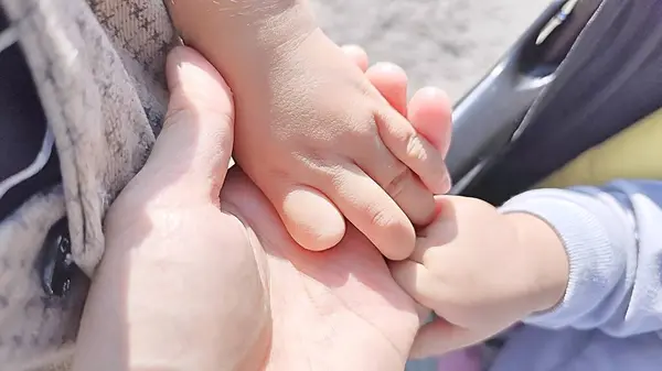 Baba dışarıda iki çocuğuyla el ele tutuşup aile bağını, sevgiyi ve birlikteliği sembolize ediyor.